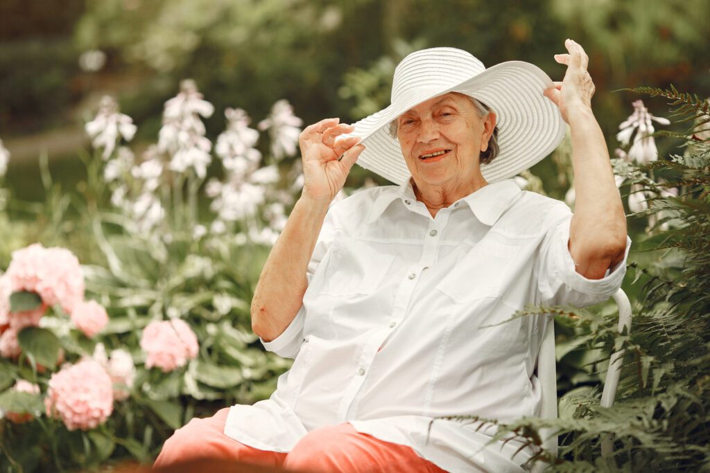 aged woman sitting park grandma white hat scaled