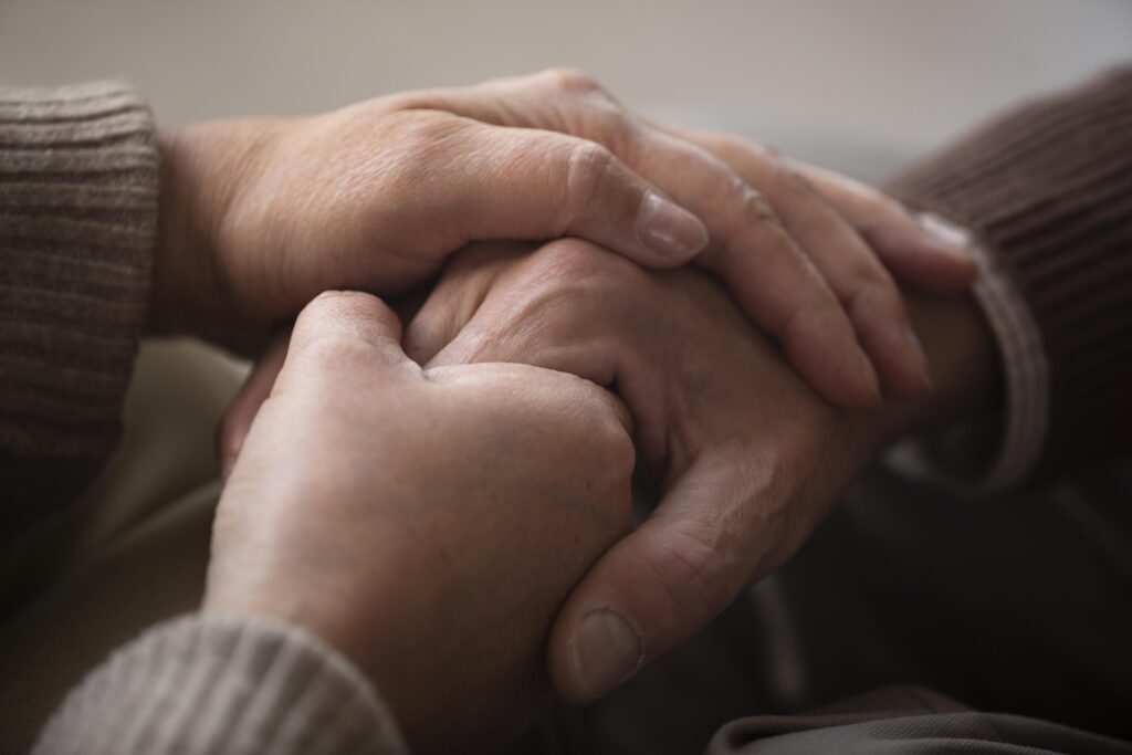 close up senior couple holding hands scaled